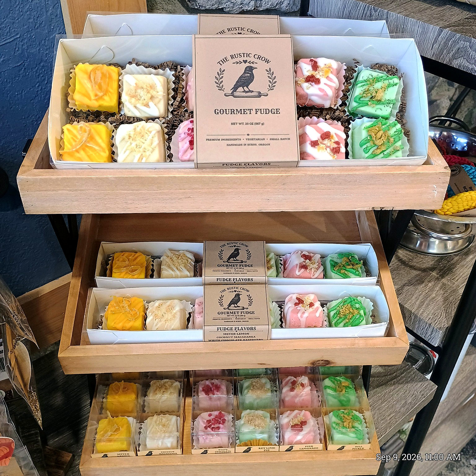 The Rustic Crow fudge display with labeled sampler boxes and individually packaged fudge