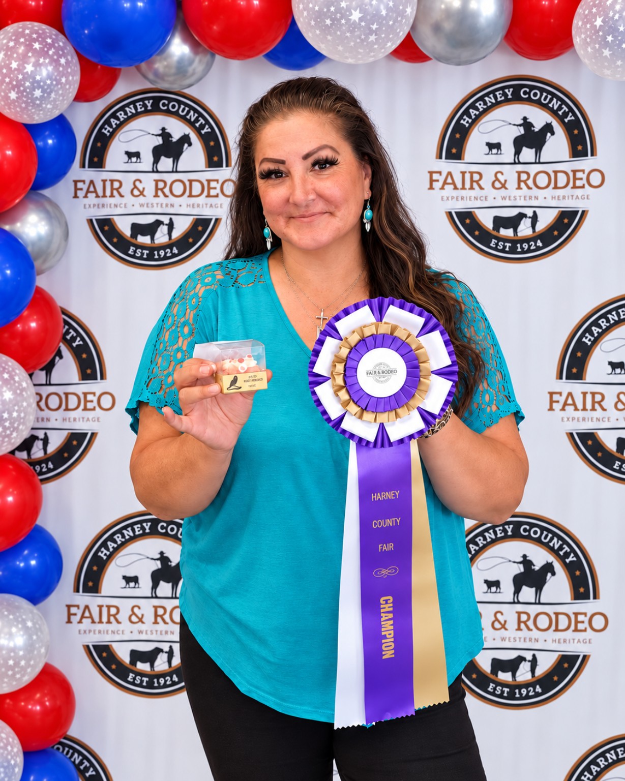 Jenn holding the purple, gold, and white Grand Champion ribbon at the Harney County Fair and Rodeo